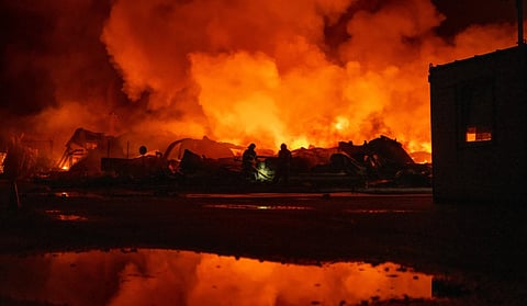 Firefighters put out a fire after Russian missiles hit a warehouse in Kyiv, Ukraine, Wednesday.