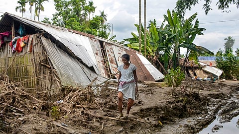 Flood-affected residents gather to receive relief materials distributed by volunteers, in Sivasagar district, Assam, Tuesday, Aug. 5, 2026. Fourteen districts and 1.6 lakh people were affected by floods in Assam while the death toll rose to 95 with six more deaths