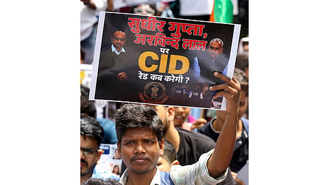 A student holds a placard as he takes part in a march towards Jharkhand Assembly as they stage a protest against the alleged JPSC-JSSC examination irregularities