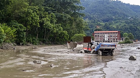Vehicles lie partially buried under thick mud and debris following flash floods at Beni Ghat area, in Dhading district, Nepal