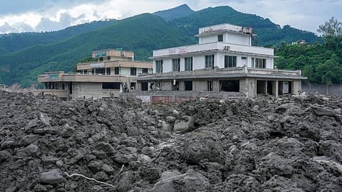 Commercial structures stand heavily damaged behind massive deposits of rocks, silt, and thick mud at Trishuli Bazar, in Nuwakot district, Nepal, Monday, Aug. 31, 2026