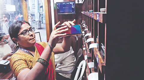 Temple staff collecting devotee's phone