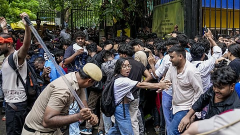 Police personnel stop Cockroach Janata Party (CJP) supporters as they raise slogans during a protest march, at Sansad Marg, in New Delhi on July 20, 2026.