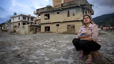 Kabita Nepal sits in front of her damaged house on the 15th day after the devastating flash flood and mudslide, at Devighat in Nuwakot.