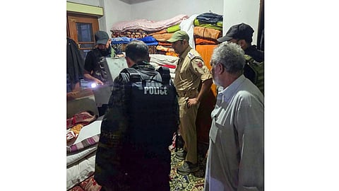 Security personnel stand guard near the residence of Kifayat Ahmad Koka, son of late Mubarak Ahmad Koka, a resident of Bugam, as a team of the National Investigation Agency (NIA) conducts a search operation, in Kulgam, Jammu and Kashmir, Saturday, Sept. 12, 2026