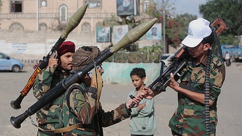 Yemen's Houthi rebels chat as they check their weapons during a mobilization campaign in Sanaa, Yemen.