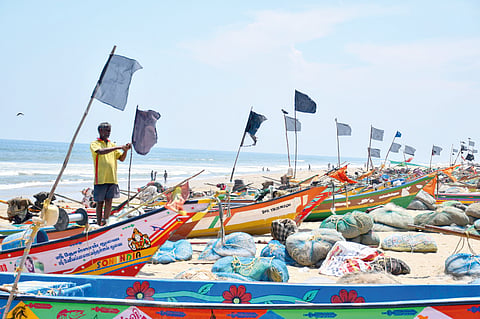 A fisherman tying black flag on his boat as part of the protest against the move to set up new Secretariat in Pattinapakkam