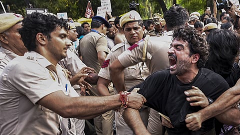 Police personnel try to evict members of the All India Students' Association (AISA), Students' Federation of India (SFI), and other student organizations during a protest demanding the resignation of Chief Election Commissioner (CEC) Gyanesh Kumar, in New Delhi.