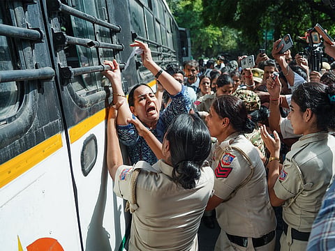 Police personnel detain a protester during a protest near Jantar Mantar, in New Delhi