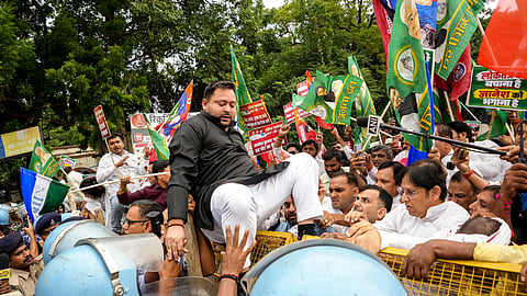 Security personnel hold back a protester attempting to scale police barricades during the INDIA bloc's march towards Lok Bhavan, in Patna, Thursday, Oct. 8, 2026. Opposition leaders and workers from RJD, Congress, and Left parties staged the demonstration against alleged irregularities in the Special Intensive Revision (SIR) of electoral rolls