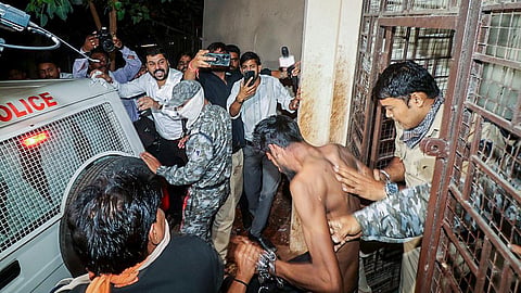 The accused, allegedly involved in a case of, rape, and blackmail of college students, is escorted by police after being produced before the district court,
in Bhopal.