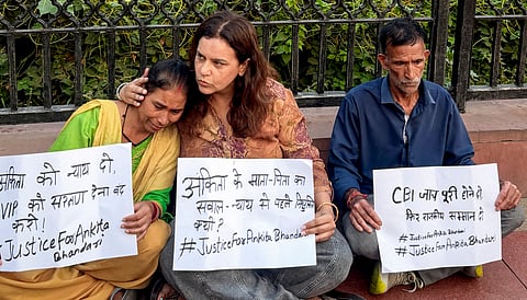 Activist Yogita Bhayana, centre, with the parents of the deceased victim Ankita Bhandari stage a sit-in protest at India Gate demanding justice for their daughter, in New Delhi