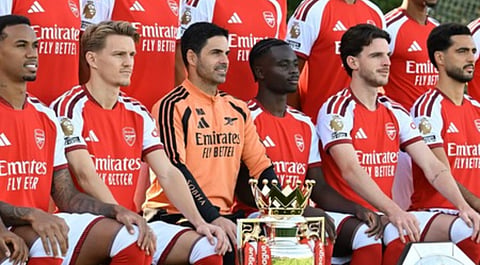 Arsenal players pose with the Premier League trophy