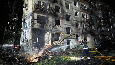 Emergency services personnel work to extinguish a fire following Russian missile attacks in Kyiv