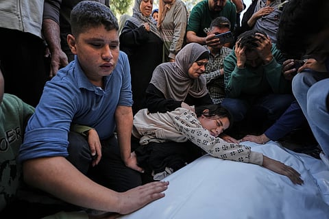 Dima Yassin mourns over the body of her mother, Dina Yassin, during the funeral of her parents, who were killed in an Israeli army strike on an apartment in Gaza City,