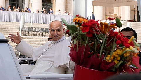 Pope Leo XIV is presented with flowers as he leaves at the end of the general audience in St. Peter's Square at The Vatican