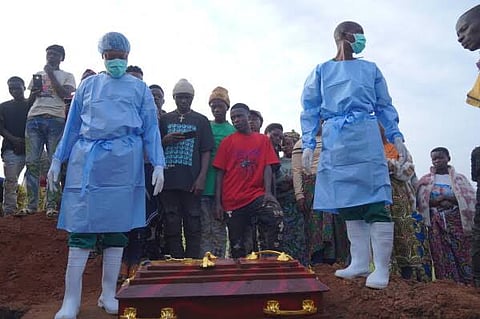 People dressed in protective gear prepare to lower into a grave the coffin containing the remains of 3-year-old Mave Mercienne, who died of Ebola, in Bunia, Ituri province, eastern Congo, Tuesday, Aug. 18, 2026