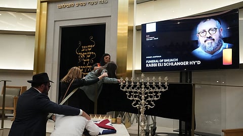 Family react at the coffin of Rabbi Eli Schlanger, a victim in the Bondi Beach mass shooting, during his funeral at a synagogue in Bondi on Wednesday, Dec. 17, 2025, in Sydney, Australia.