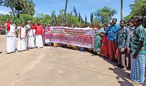 Group of residents stage a protest holding black flags in Thanjavur village