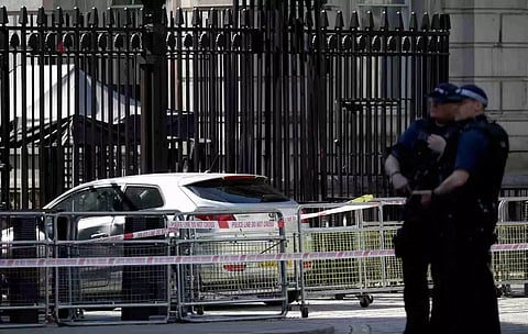 Police officers stand guard neat the site where a car crashed into the front gates of Downing Street in London. (Reuters)