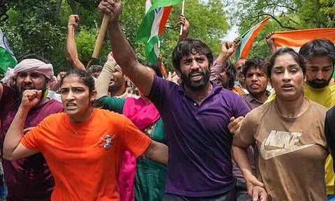Wrestlers Vinesh Phogat, Sangeeta Phogat, and Bajrang Punia with supporters during their protest march towards new Parliament building, in New Delhi, Sunday. (PTI)