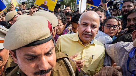 Delhi Police personnel escort Manish Sisodia from Rajghat ahead of his questioning by CBI