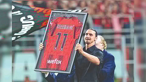 Zlatan Ibrahimovic holds a framed jersey
