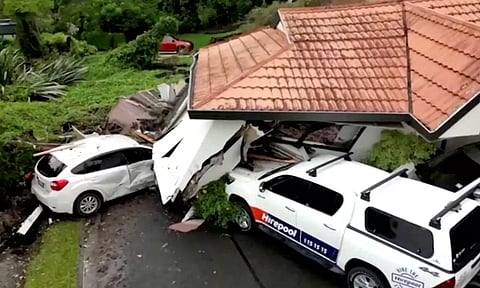  A view of a house that had collapsed on vehicles, following floods