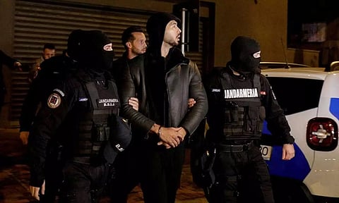 Andrew Tate and Tristan Tate are escorted by police officers outside the headquarters of the Directorate for Investigating Organized Crime and Terrorism in Bucharest (DIICOT) after being detained for 24 hours, in Bucharest, Romania. (Reuters)