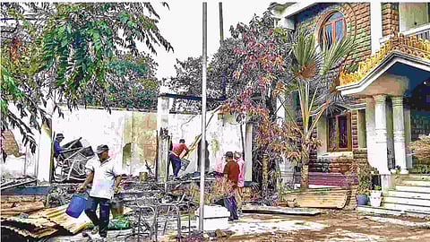 Workers attempt to salvage burnt items at Ranjan Singh’s residence in Imphal