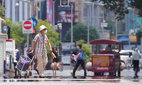 A man wearing a face mask pulls a cart on a street amid a heatwave warning, following the coronavirus disease (COVID-19) outbreak in Shanghai, China (Reuters)