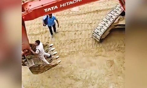 An RPF constable climbs to an earthmover to access the undergear of the train