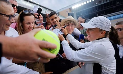 Tennis - French Open - Roland Garros, Paris, France - June 10, 2023 Poland's Iga Swiatek signs autographs for fans after winning her final match against Czech Republic's Karolina Muchova (PHOTO: REUTERS)
