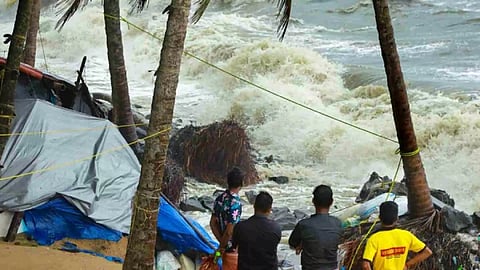 Locals gather near the debris of a house on the beach that was damaged by the rough sea during the ongoing monsoon season, in Kozhikode, Friday (Photo: PTI)