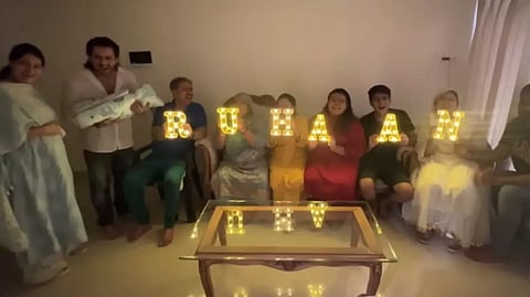 The name was announced via bright lights given to each of the family members, who took turns and held the lit letters in front of them to reveal the name.