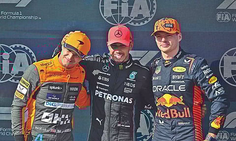 Lando Norris, pole position winner Lewis Hamilton and second placed Max Verstappen pose after the qualifying session