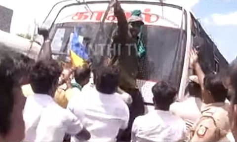 A PMK supporter climbing on the police van. Thanthi TV screengrab