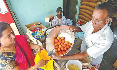 A woman buys tomatoes from a Fair Price Shop (FPS) at Gandhinagar in Vellore