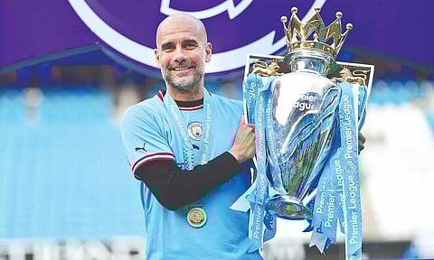 Pep Guardiola poses with the EPL trophy.