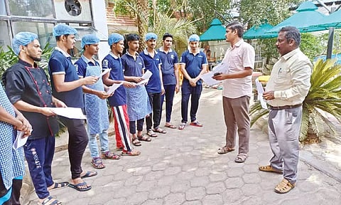 Labour Department officials interacting with migrant workers and handing over pamphlets