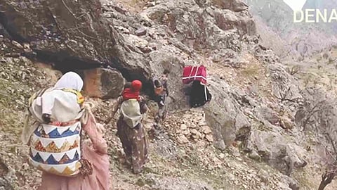 Group of people are seen making a difficult trek through the mountains