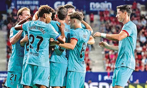 Barcelona players celebrate a goal against Osasuna FC