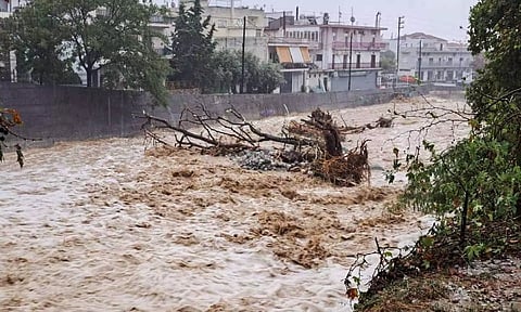 A fallen tree is seen in a flooded river during a storm