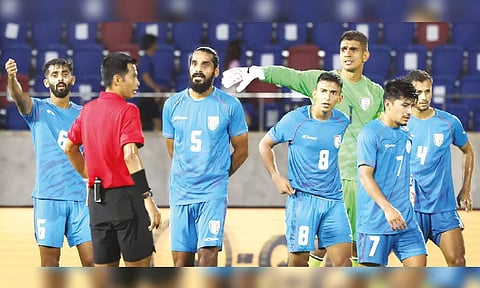 Indian players surround the referee after penalty being awarded for the challenge on Aymen Ghadhban 