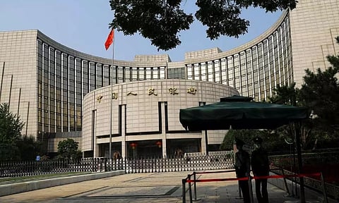 Paramilitary police officers stand guard in front of the headquarters of the People's Bank of China