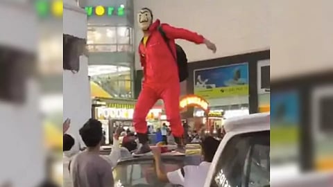 Masked man showers notes standing on car’s roof (IANS)