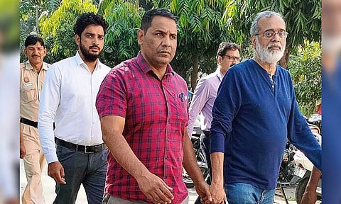 NewsClick founder Prabir Purkayastha (right) being brought to the Patiala House Court by Delhi Police’s Special Cell in a case lodged under anti-terror law UAPA, in New Delhi. (PTI)