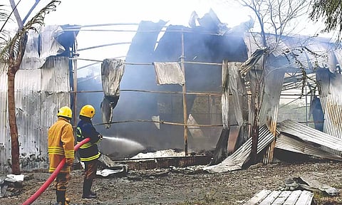 Fire personnel dousing fire after an explosion at a cracker shop-cum-packing unit in Rengapalayam near Sivakasi.