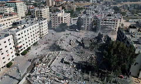 Palestinians gather around residential buildings destroyed in Israeli strikes