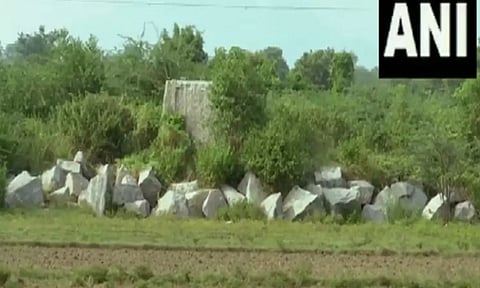 Visuals of granite stones placed near the farming land and ponds